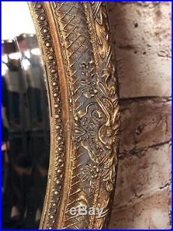Glace / miroir ovale style Louis XVI patiné doré