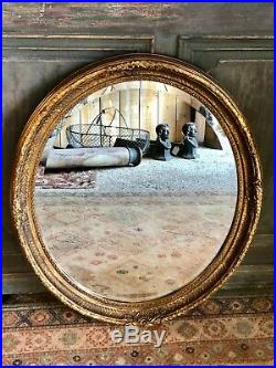 Glace / miroir ovale style Louis XVI patiné doré