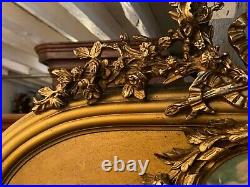 Miroir trumeau doré glace biseautée à décor de fronton style Louis XVI