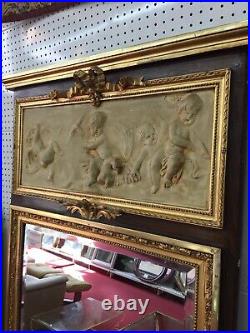 Miroir trumeau style Louis XVI verre biseauté et fronton plâtre décors puttis