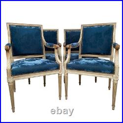 Suite de quatre fauteuils de style Louis XVI, bois laqué blanc et velours bleu