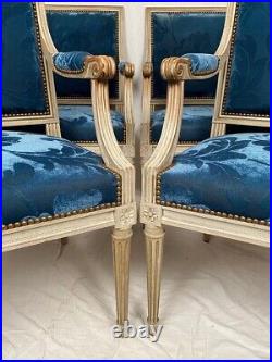 Suite de quatre fauteuils de style Louis XVI, bois laqué blanc et velours bleu