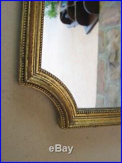 Superbe miroir mural doré à la feuille d'or style Louis XVI